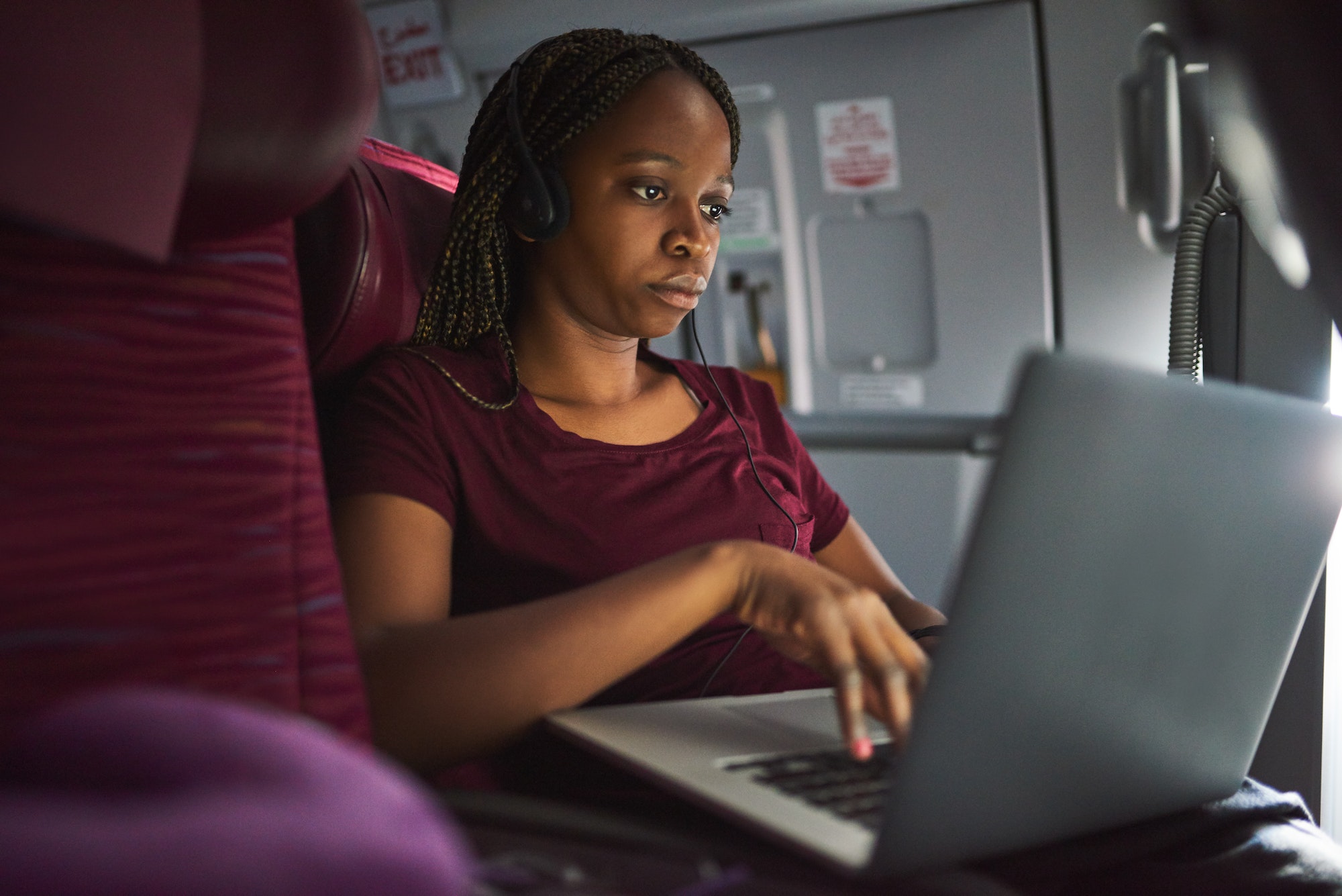 Cropped shot of an attractive young woman using her laptop while sitting on a plane